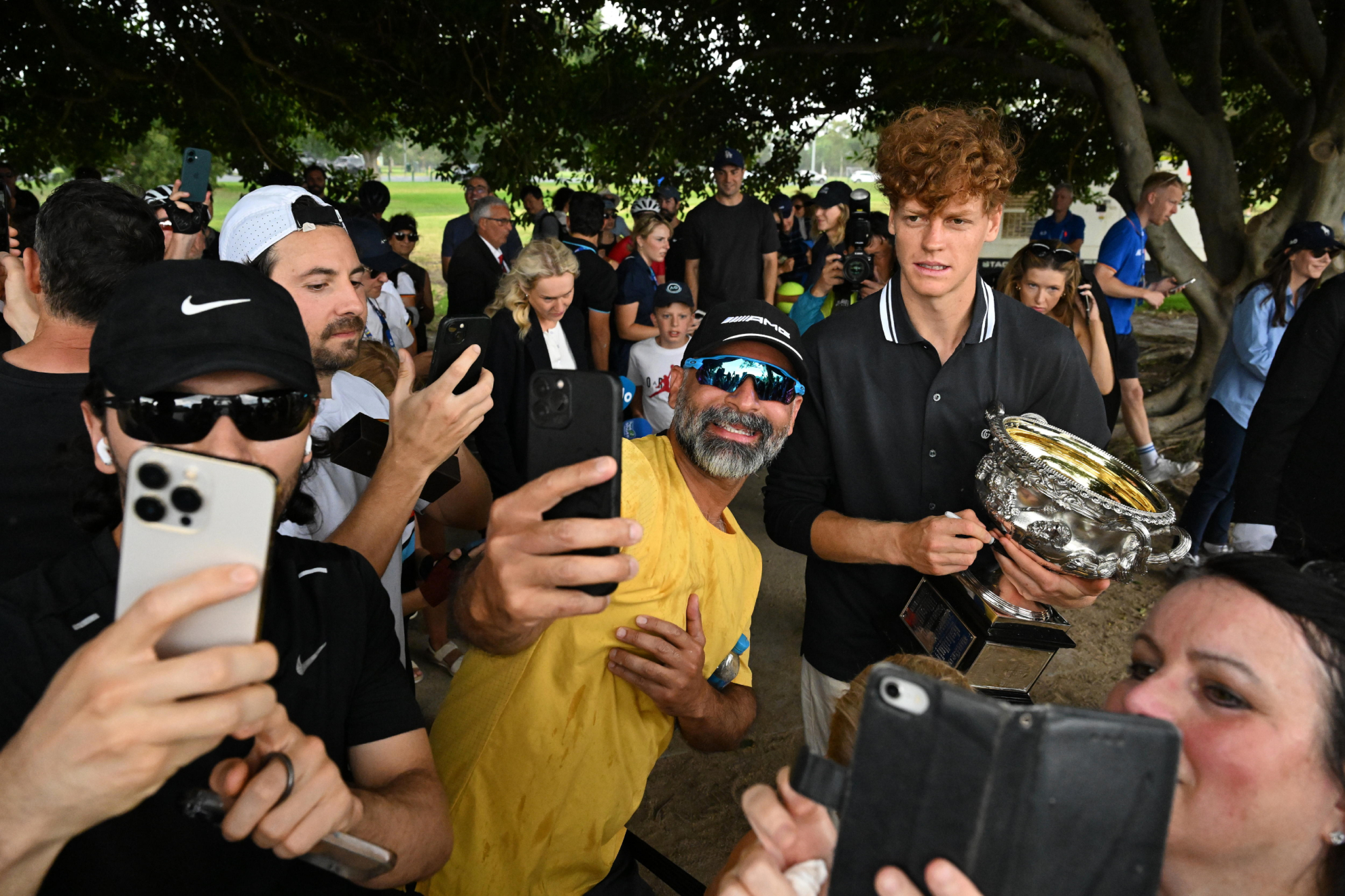 Jannik Sinner posa para selfies con el trofeo del Open Australia.