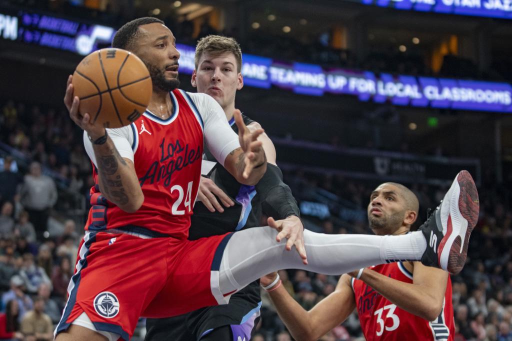 Norman Powell intenta dar un pase perseguido por Kyle Filipowski.