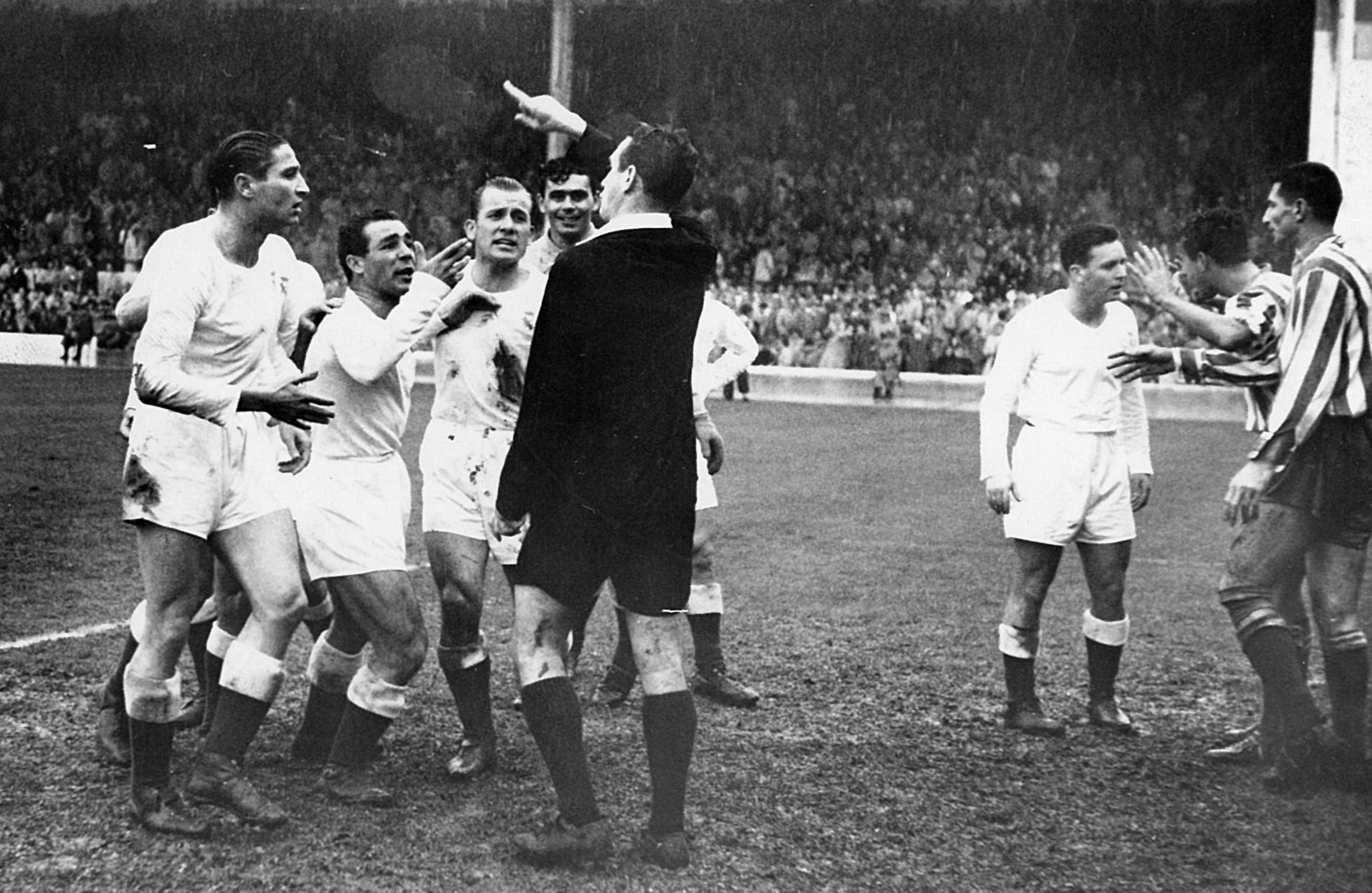 El árbitro González Echeverría, rodeado de madridistas que le protestan durante un derbi.