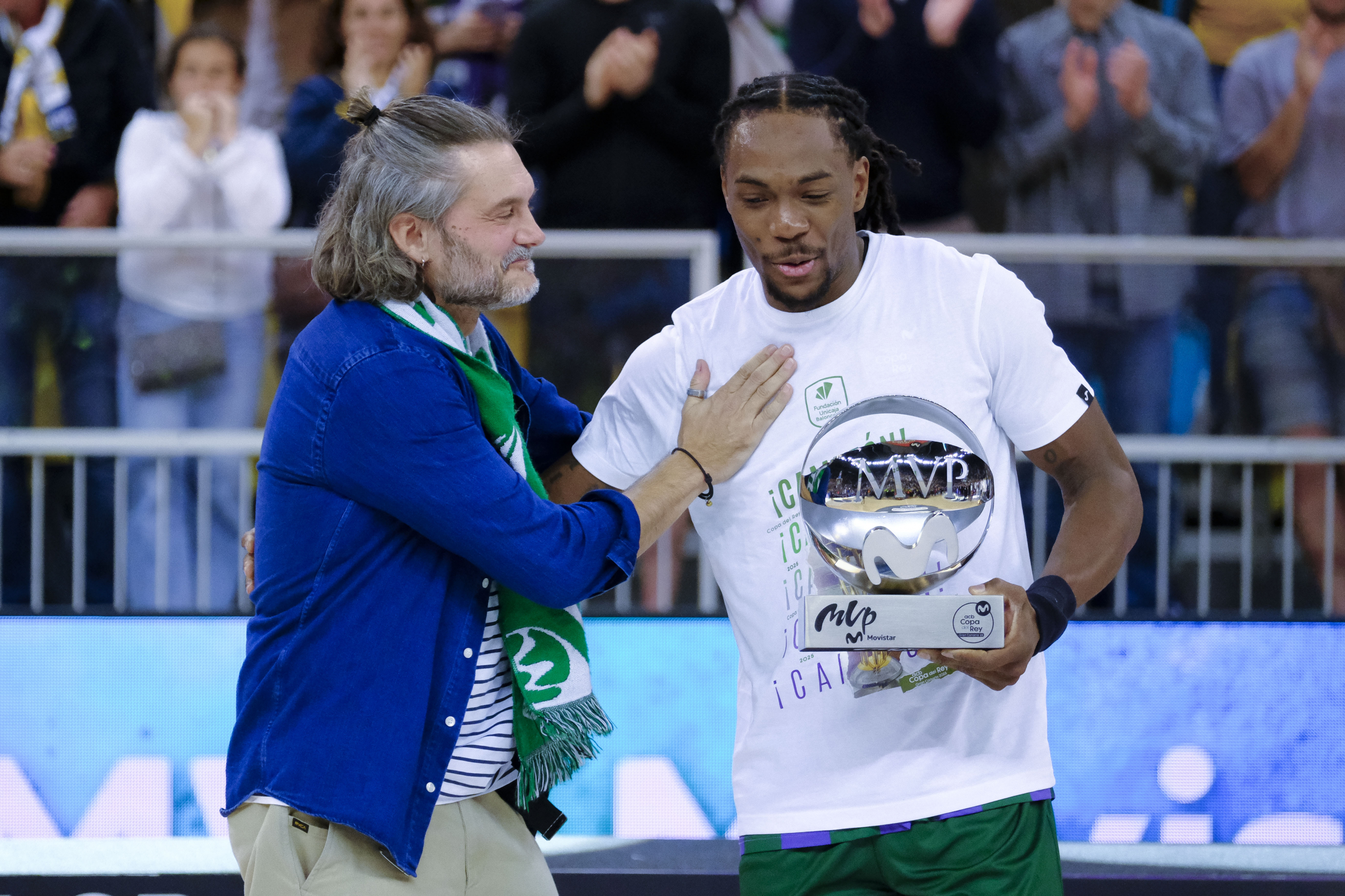 LAS PALMAS DE GRAN CANARIA, 16/02/2025.- El base del Unicaja Kendrick Perry (d) recibe el trofeo de mejor jugador del partido tras la final de la Copa de Rey de baloncesto que Real Madrid y Unicaja Málaga disputaron este domingo en el Gran Canaria Arena, en Las Palmas de Gran Canaria. EFE/Ángel Medina G.
