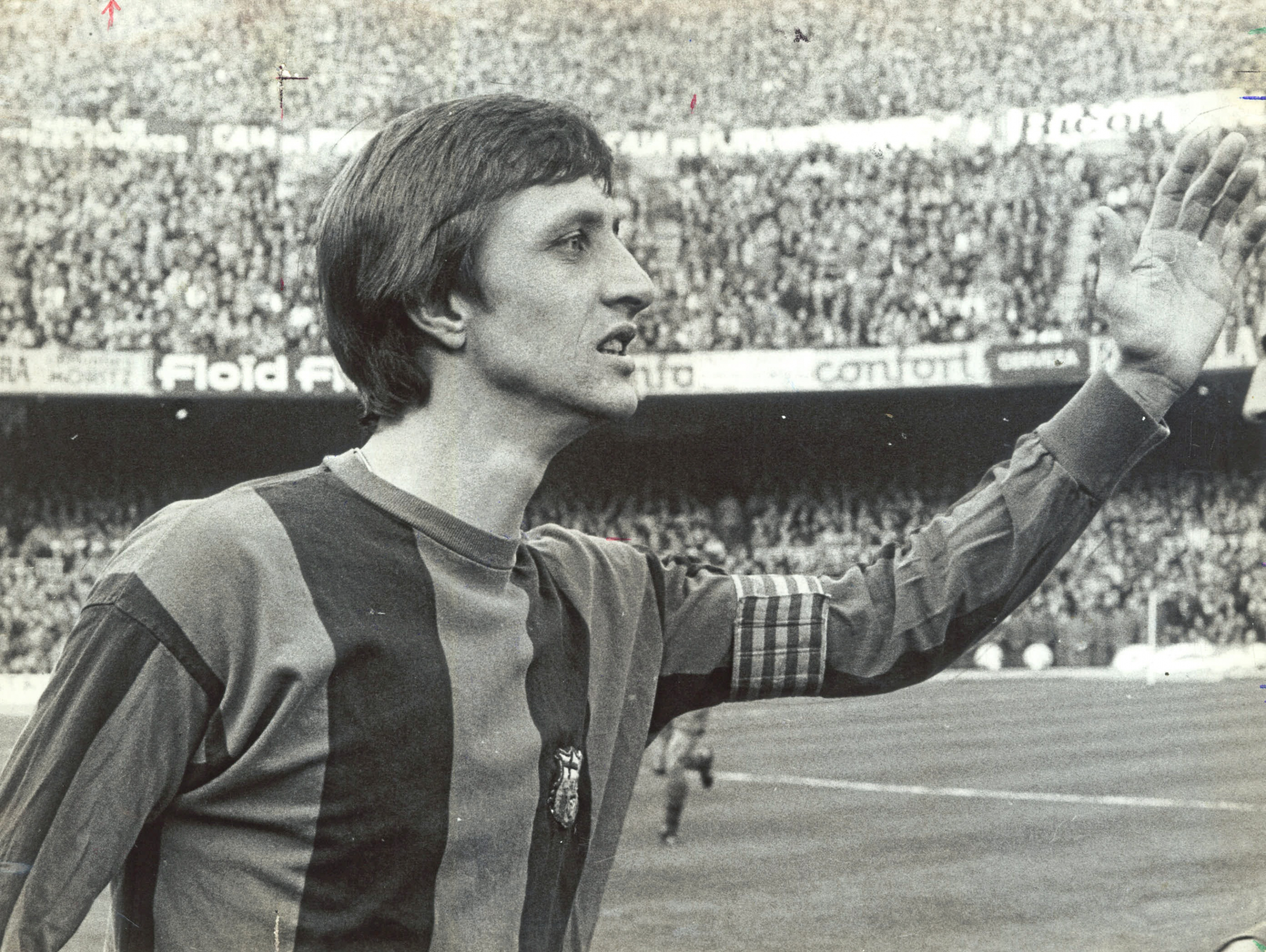 Cruyff levanta su brazo e indica algo a un compañero.