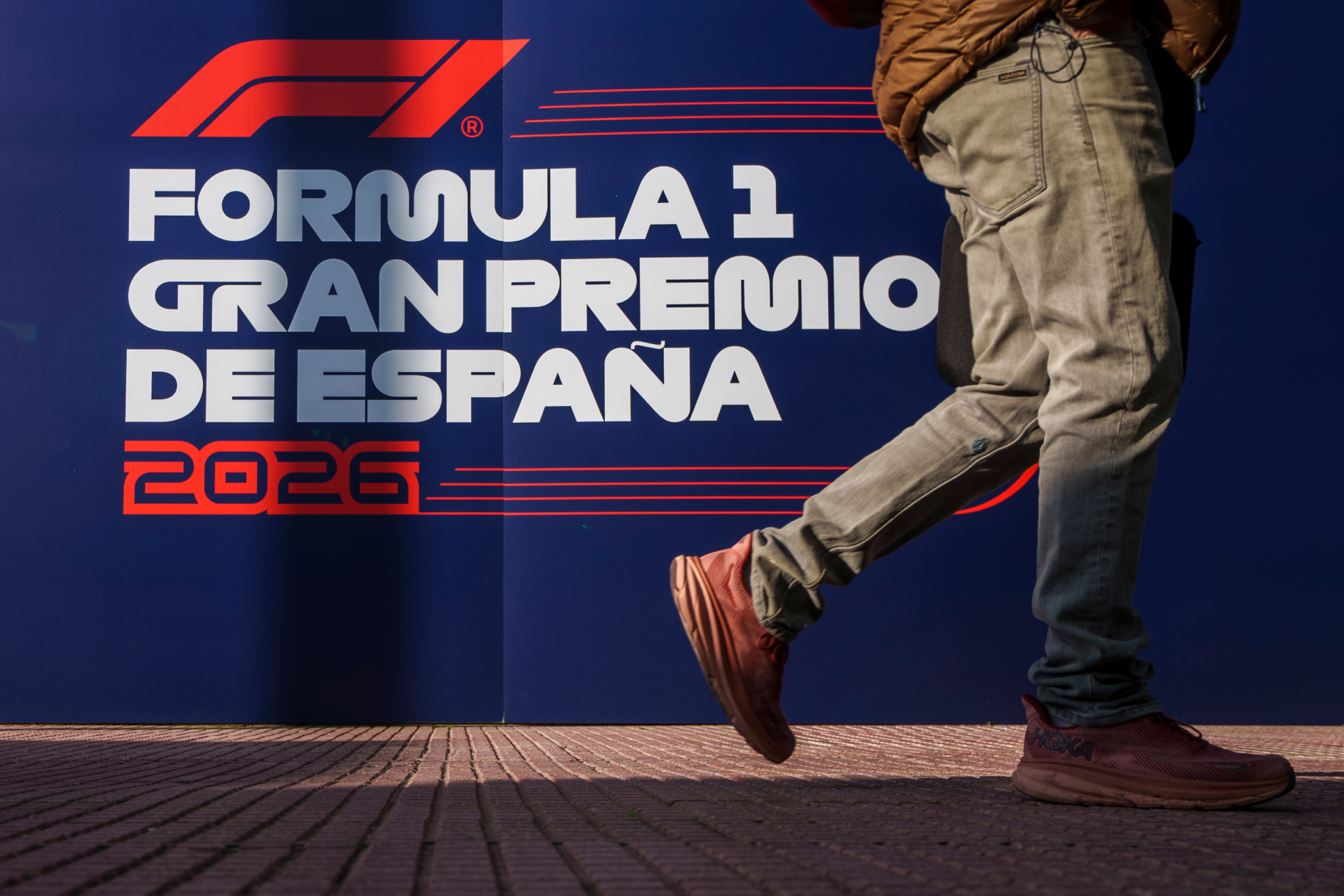 Un hombre pasa delante de un logo de la F1 en Madrid.