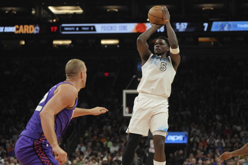 Anthony Edwards lanza delante de Mason Plumlee.