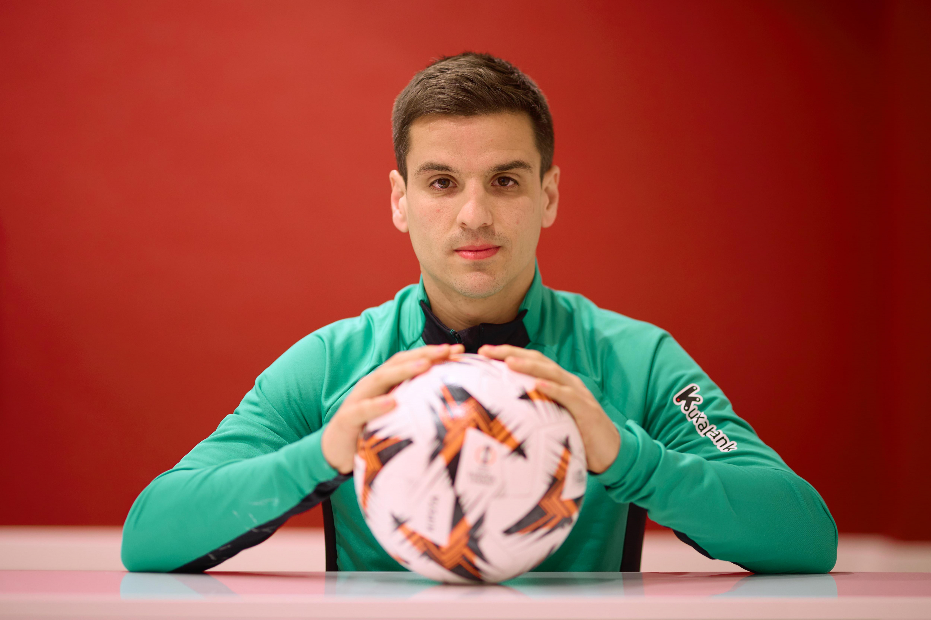 El futbolista rojiblanco agarra un balón de la Europa League.