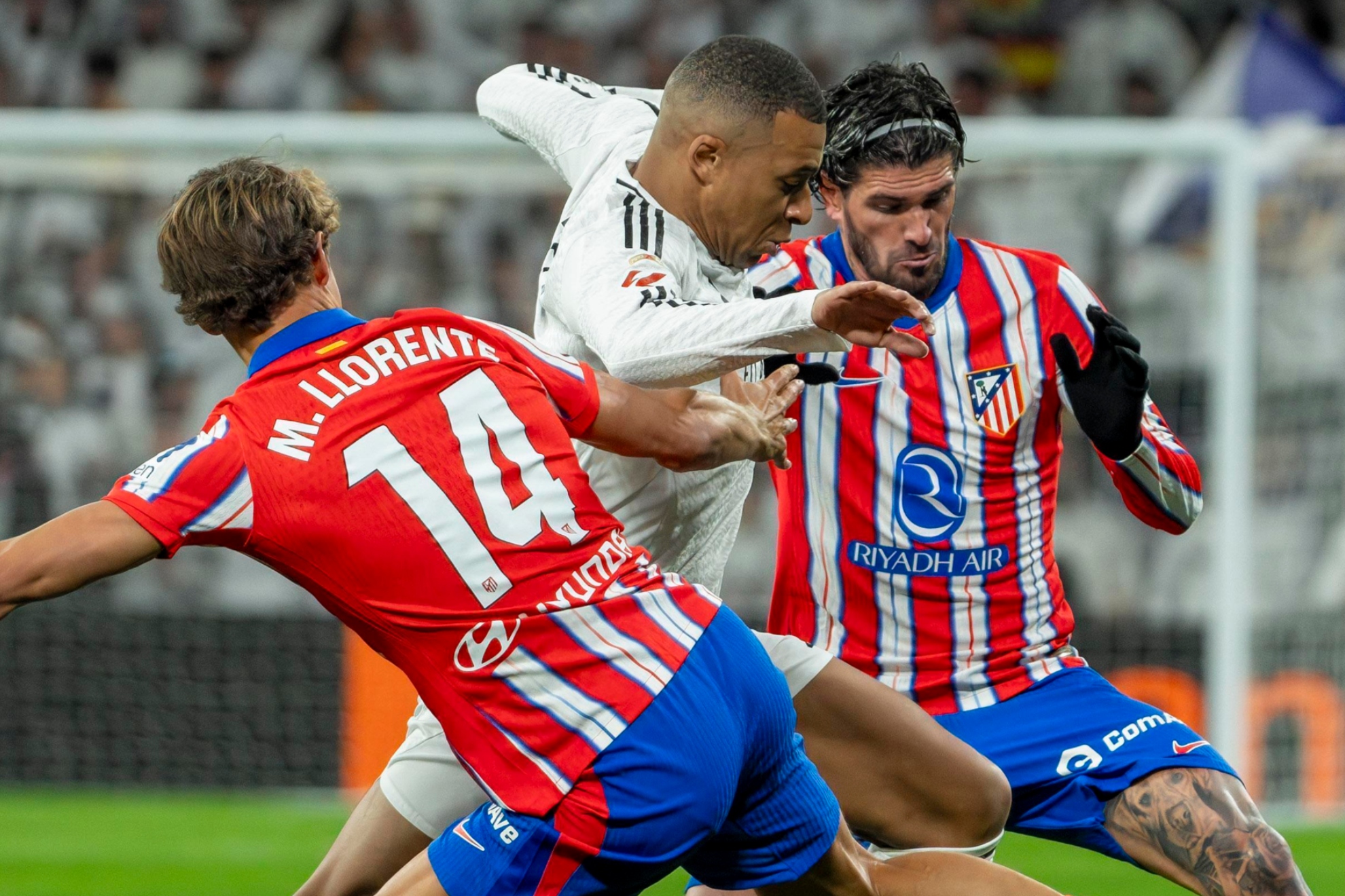 Mbappé conduce el balón entre Llorente y De Paul.