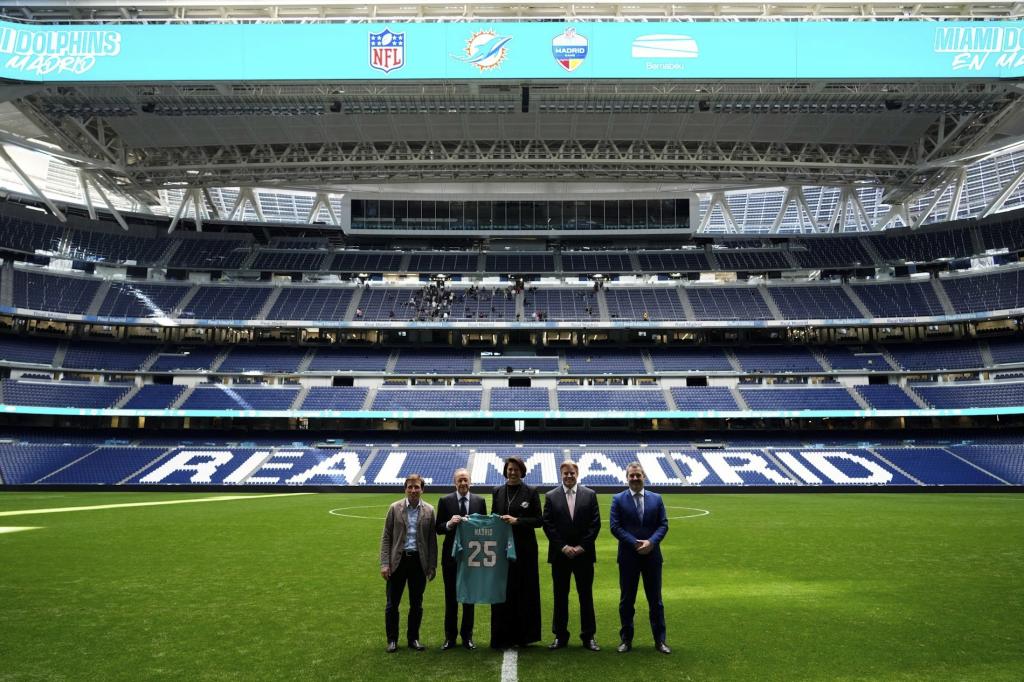 Martínez-Almeida y Florentino Pérez, en un acto con los Miami Dolphins en el Santiago Bernabéu.