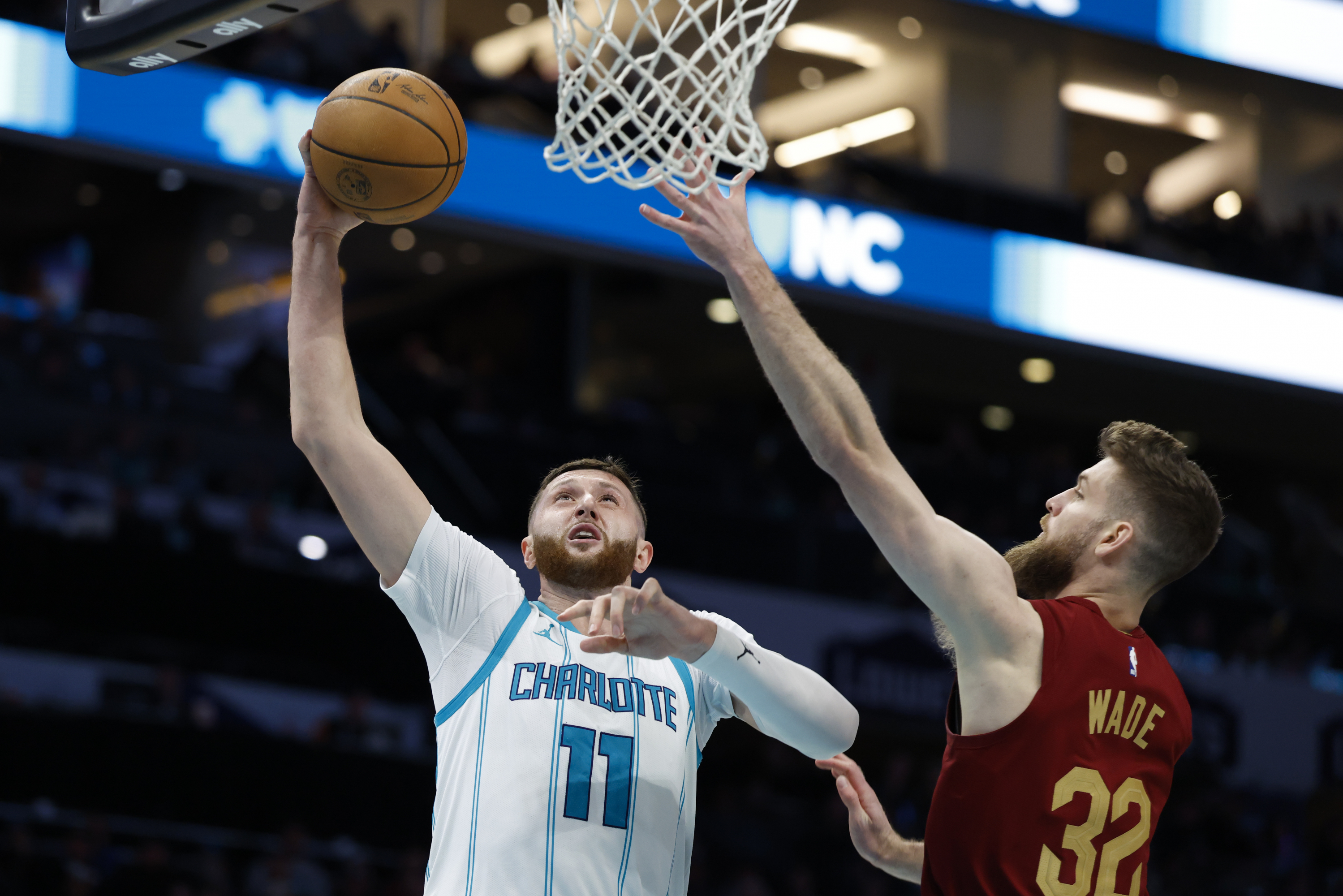 Jusuf Nurkic (11), de los Charlotte Hornets tratando de superar a Dean Wade de los Cleveland Cavaliers.