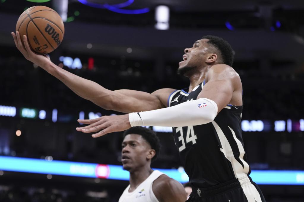 Giannis Antetokounmpo enters a basket in front of De'andre Hunter.