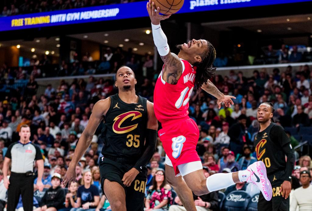 Ja Morant prepares to score in an acrobatic position after overcoming Isaac Okoro.