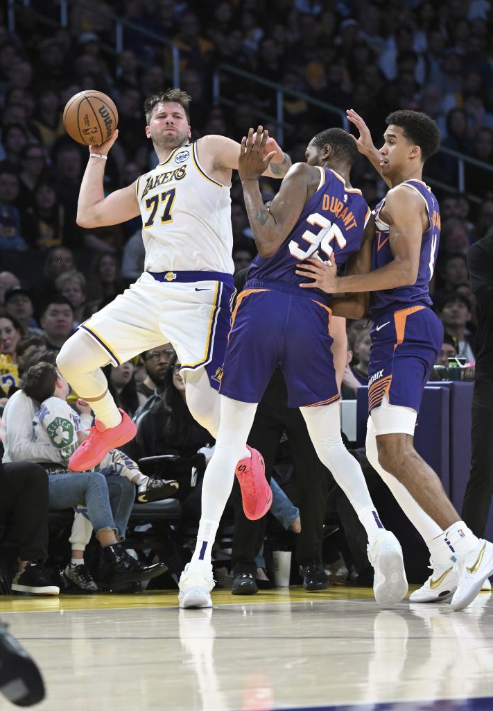 Luka Doncic intenta salvar un balón por la línea de banda.
