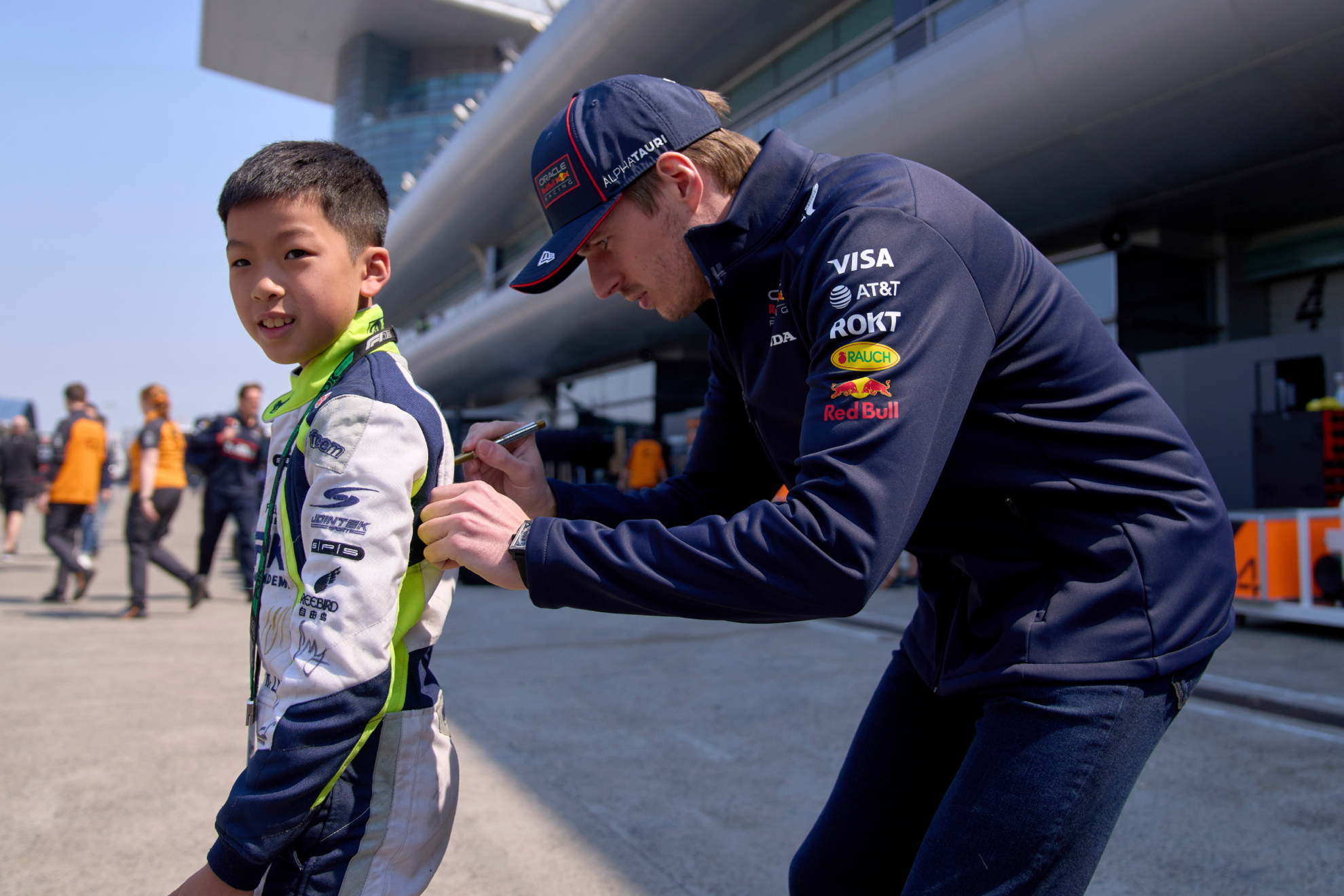 Max firma un autógrado a un joven fan en el circuito de Shanghái.