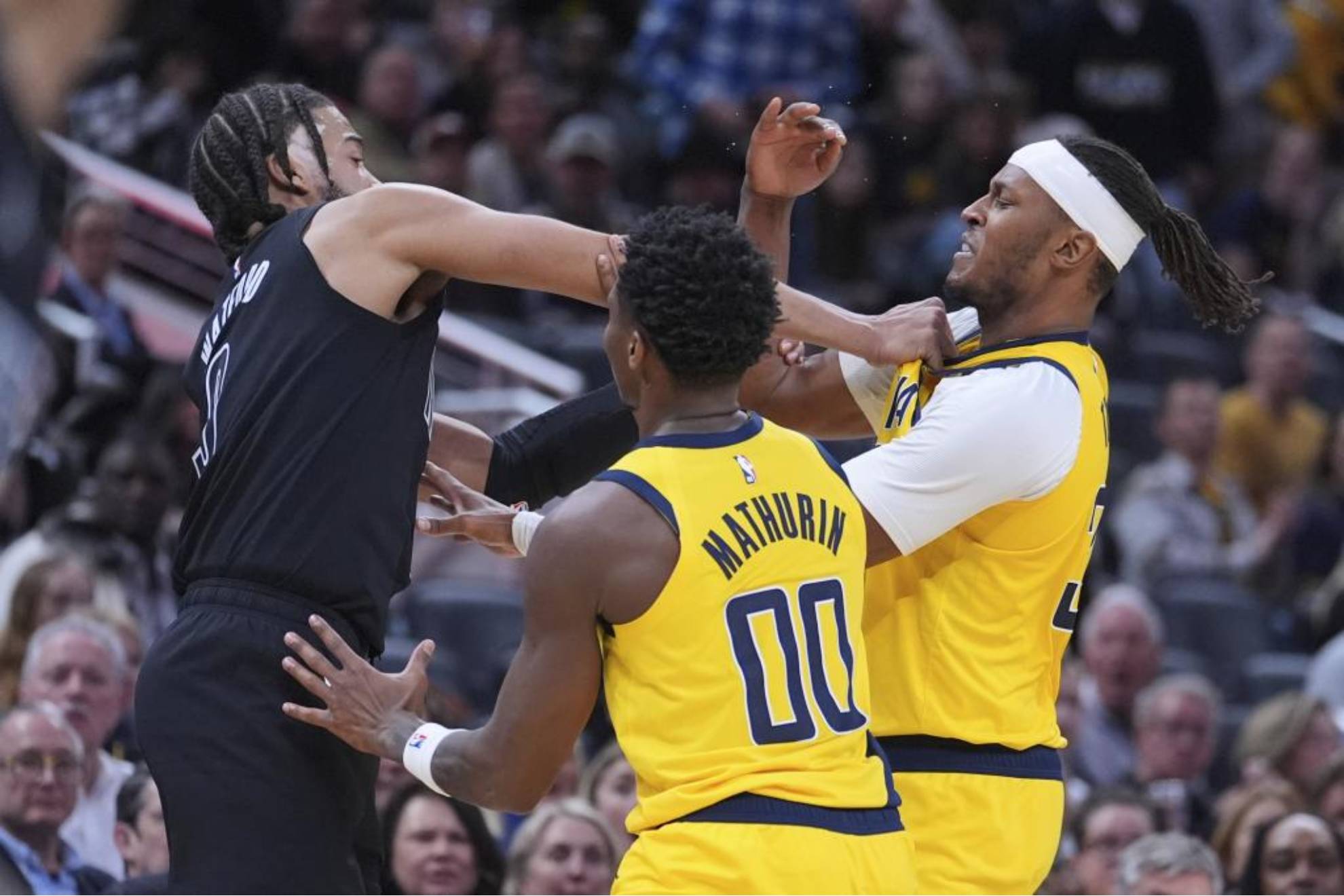 Trendon Watford intenta golpear a Myles Turner.