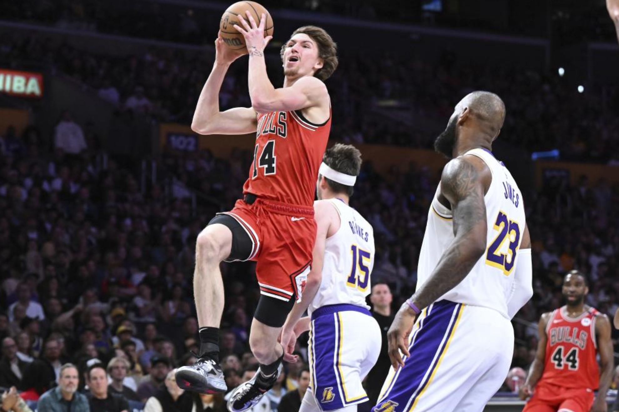 Matas Buzelis entra a canasta ante la mirada de LeBron James.