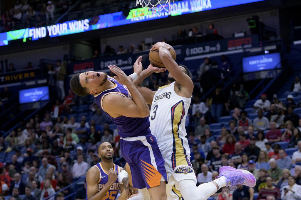 CJ McCollum defends against Devin Booker during a Suns-Pelicans game.