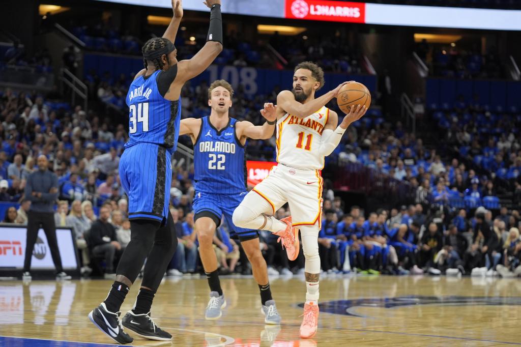Trae Young pressured by Wendell Carter Jr. and Franz Wagner.