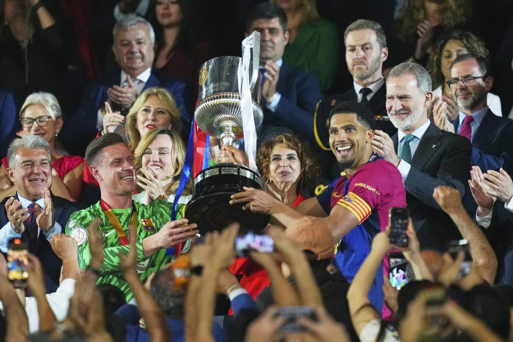 Ronald Araujo and goalkeeper Marc-André Ter Stegen from Barcelona raise the trophy after winning the final of the Copa del Rey de España against Real Madrid. (PHOTO AP/José Bretón)
