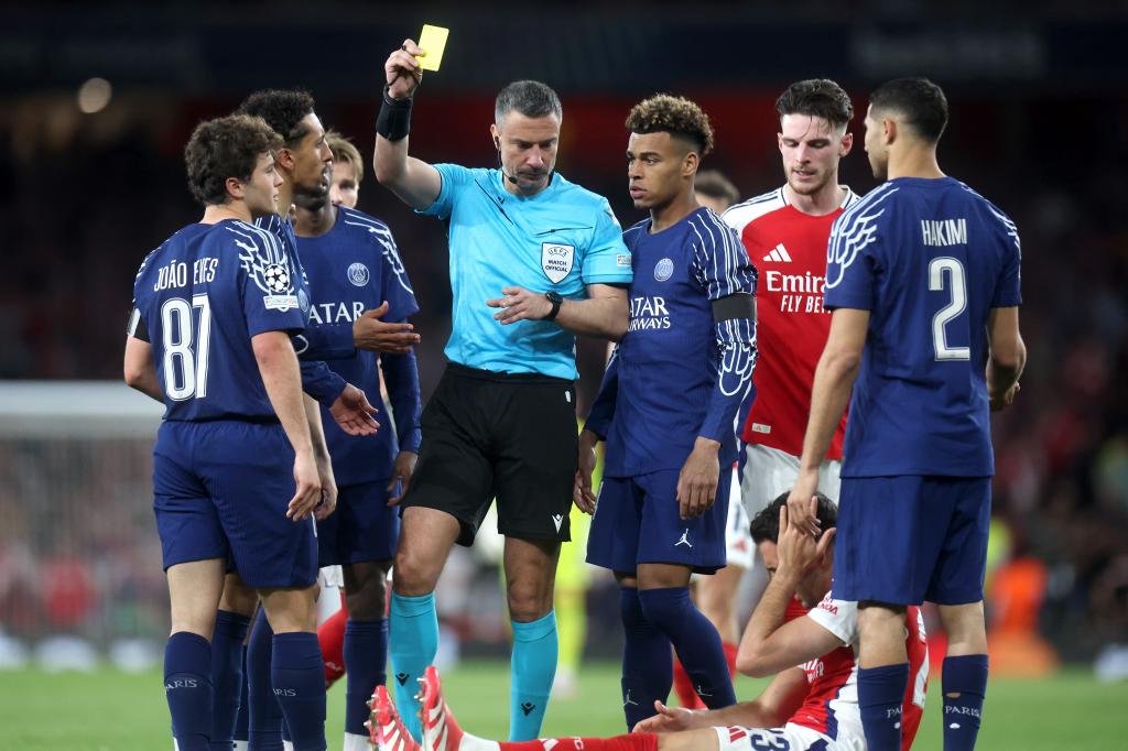 Joao Neves (L) of PSG is shown the yellow card by referee Slavko Vincic during the UEFA Champions League semi-finals. EFE/EPA/NEIL HALL