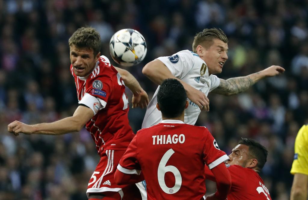 Thomas Müller and Toni Kroos fight for a ball in a Bayern-Real Madrid.