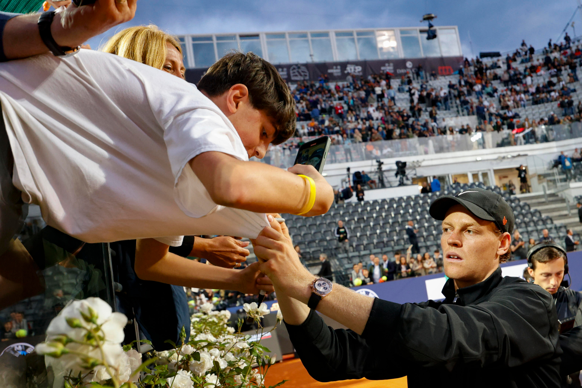 Jannik Sinner firma una camiseta tras su partido ante Casper Ruud en el Foro Itálico romano.