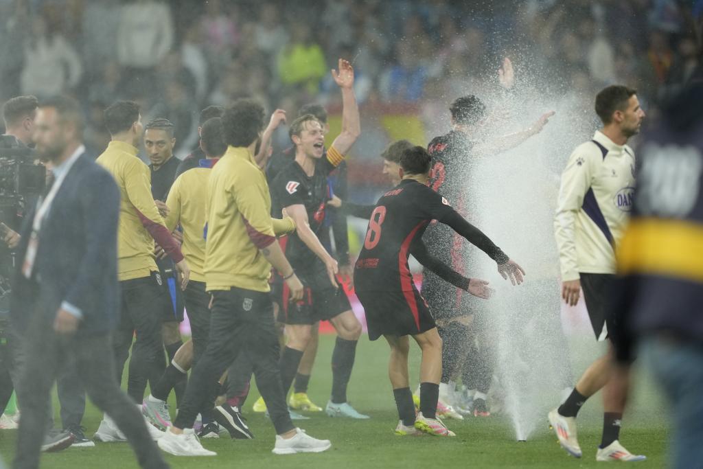 يحتفل لاعبو برشلونة بفوزهم في الدوري بعد الفوز على إسبانيول.