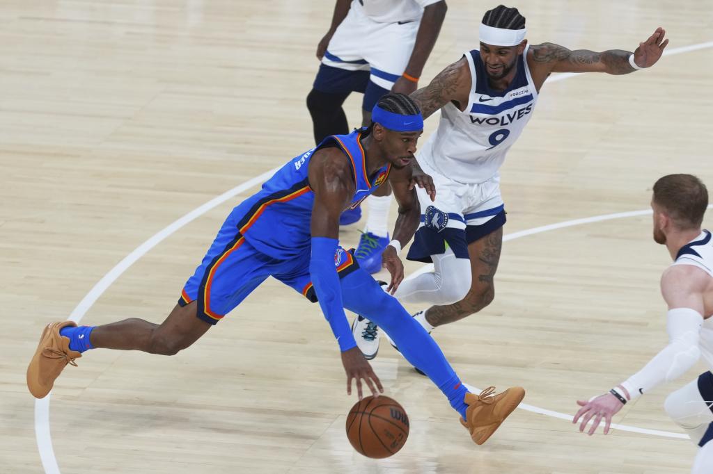 Shai Gilgeous-Alexander trata de superar la defensa de Nickeil Alexander-Walker.
