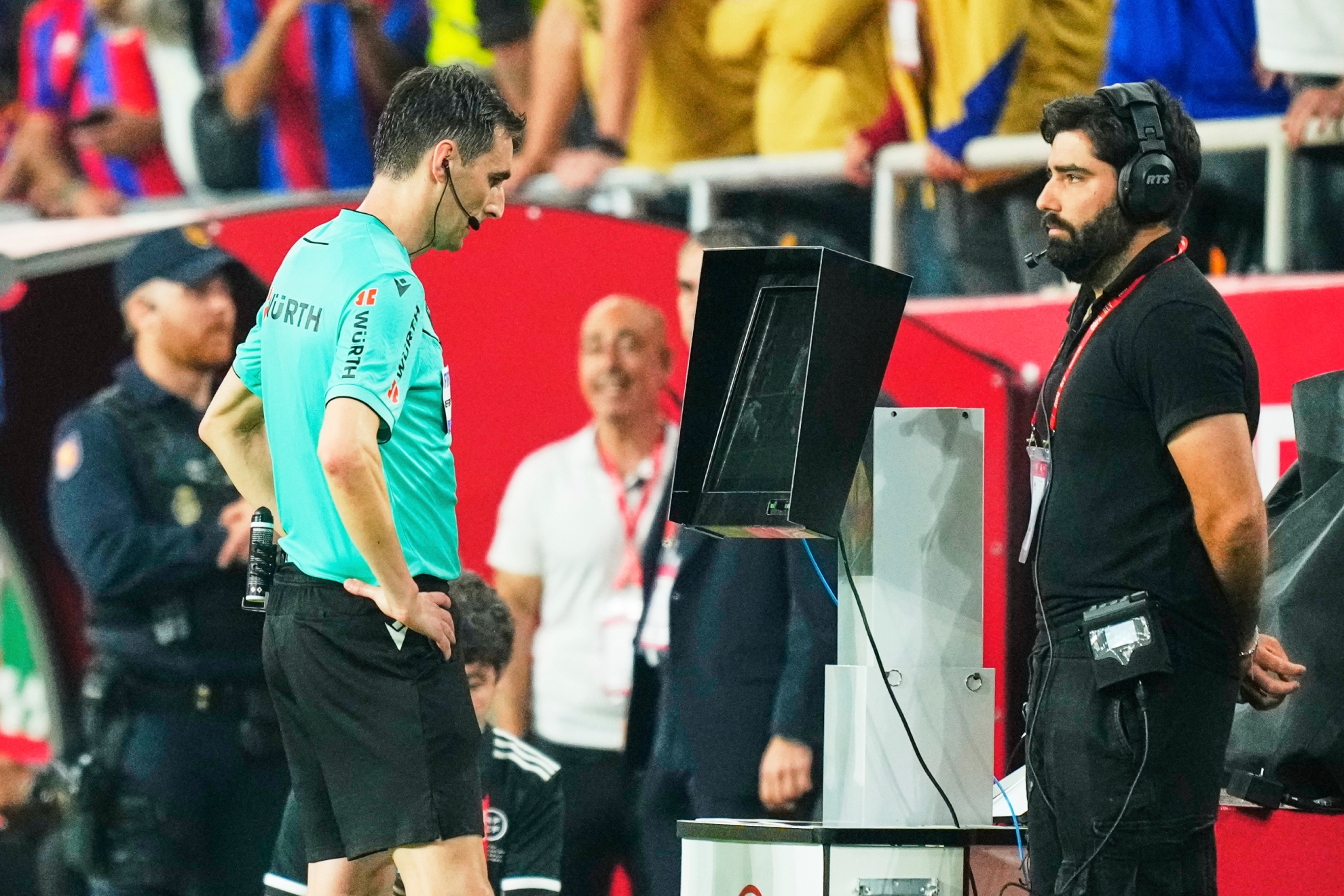 Referee Ricardo de Burgos Bengoetxea reviews the VAR during the Rety Cup final between Barcelona and Real Madrid, on Saturday, July 26, 2025, in Seville. (AP Photo/José Breton)