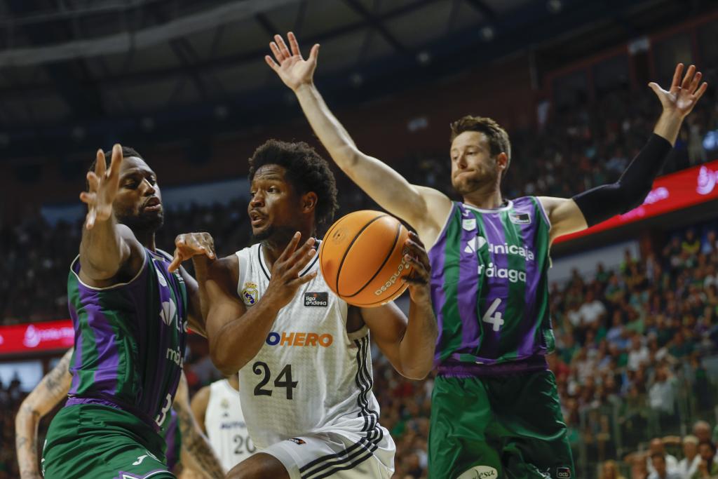Andrés Happy plays a ball between Melvin Ejim and Tyler Kalinoski.