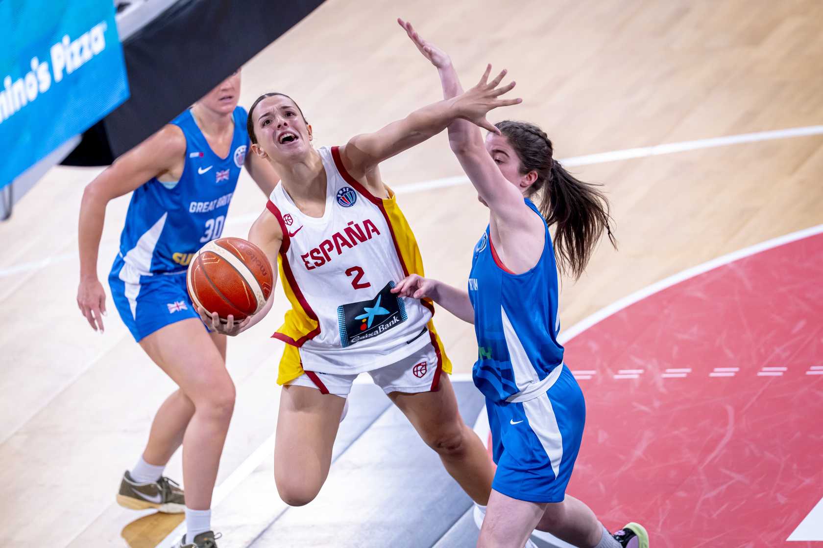 Elena Buenavida entre dans le panier entre deux joueurs de la Grande-Bretagne.