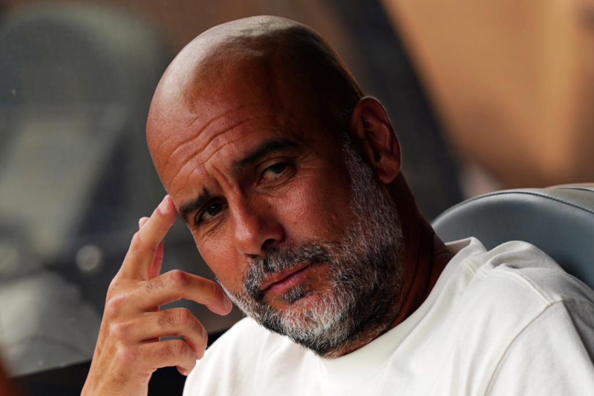 Pep Guardiola, with thoughtful gesture on the bench.