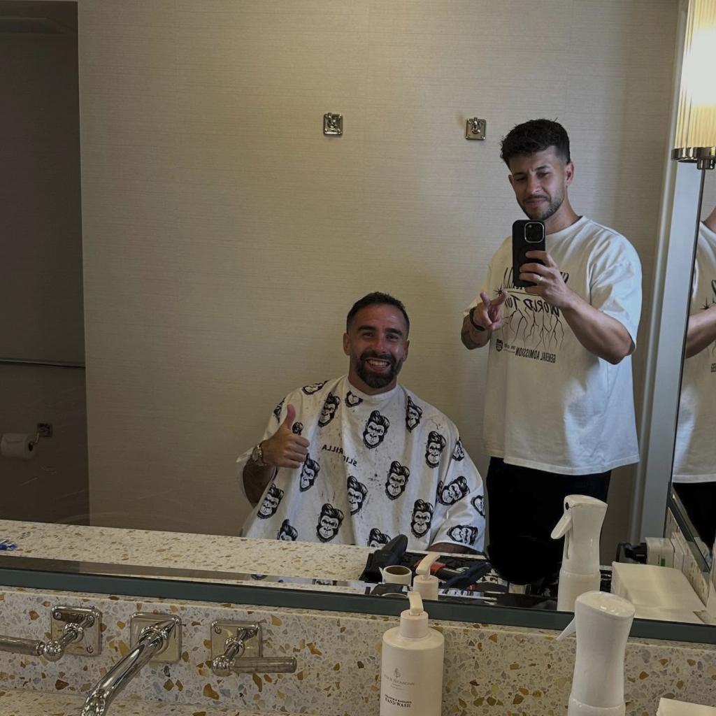 Oliva and Carvajal pose for a photograph after the haircut at the Madrid concentration hotel.