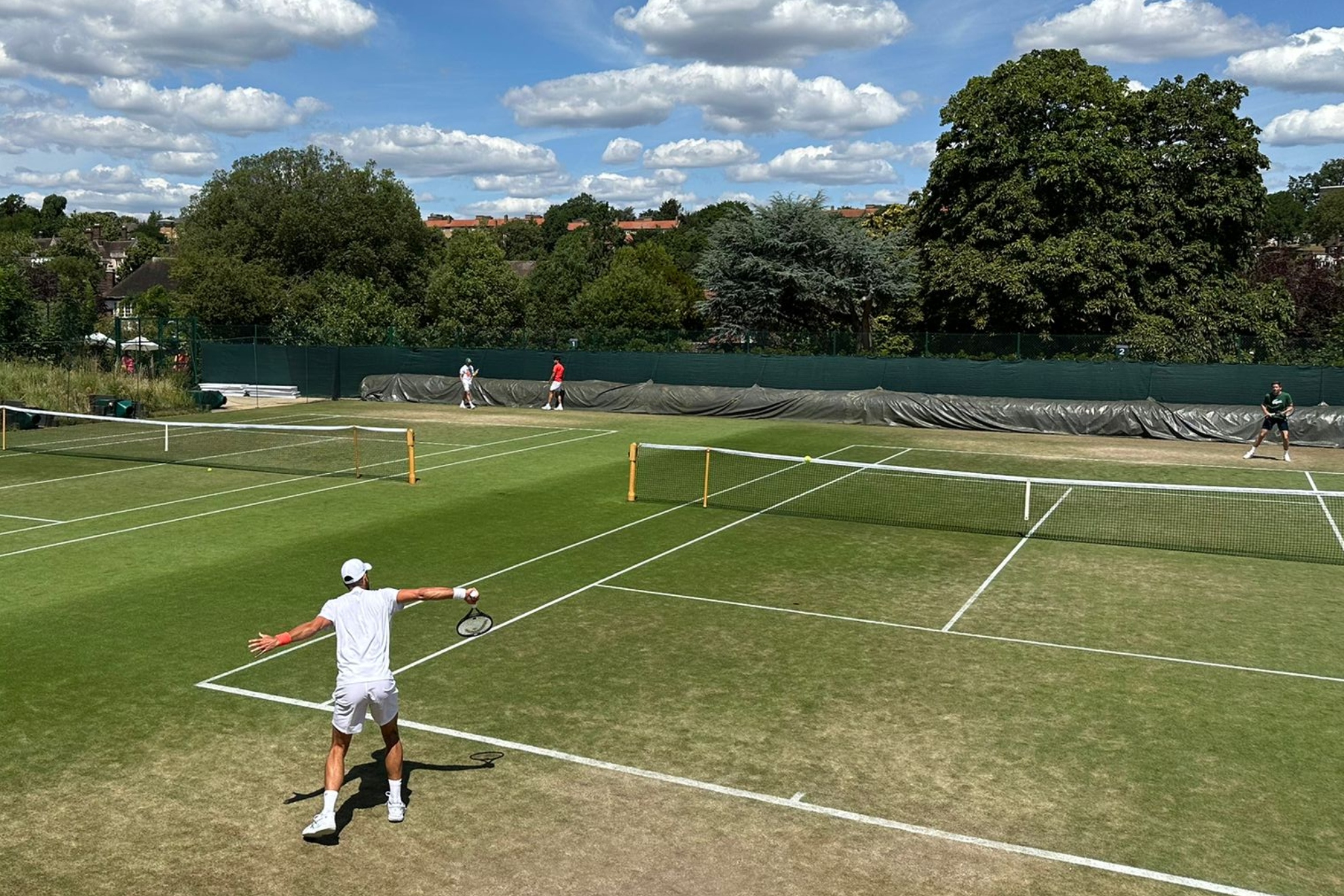 Djokovic trains on the track next to Alcaraz's.