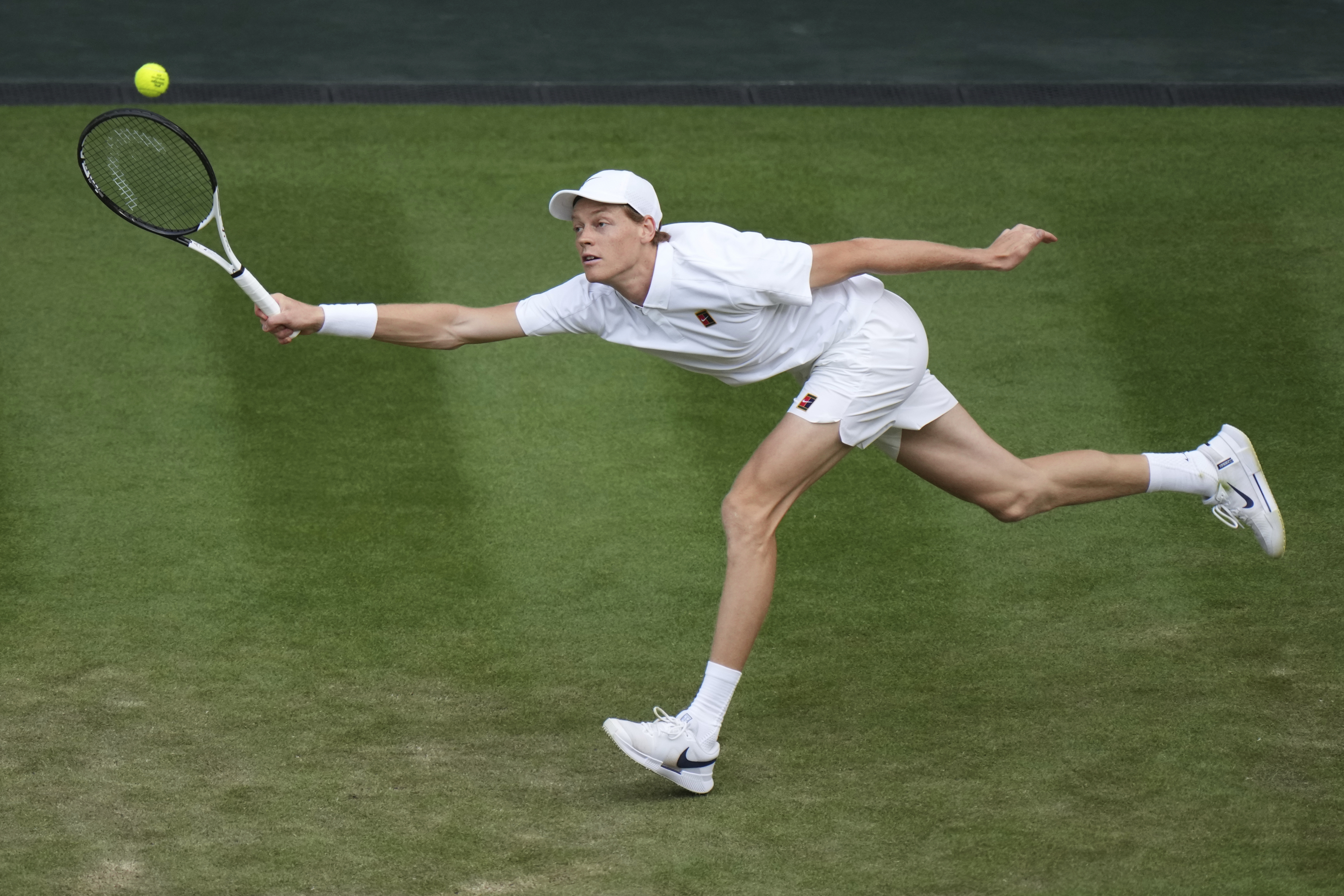 Jannik Sinner stretches to hit a ball against Vukic.