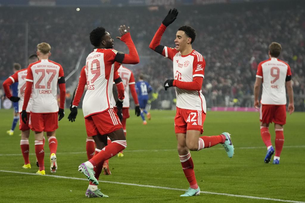 Bayern's Jamal Musiala, right, celebrates with Alphonso Davies after scoring the opening goal during the German Bundesliga soccer match between FC Bayern Munich and TSG 1899 Hoffenheim at the Allianz Arena in Munich, Germany, Friday, Jan. 12, 2024. (AP Photo/Matthias Schrader)