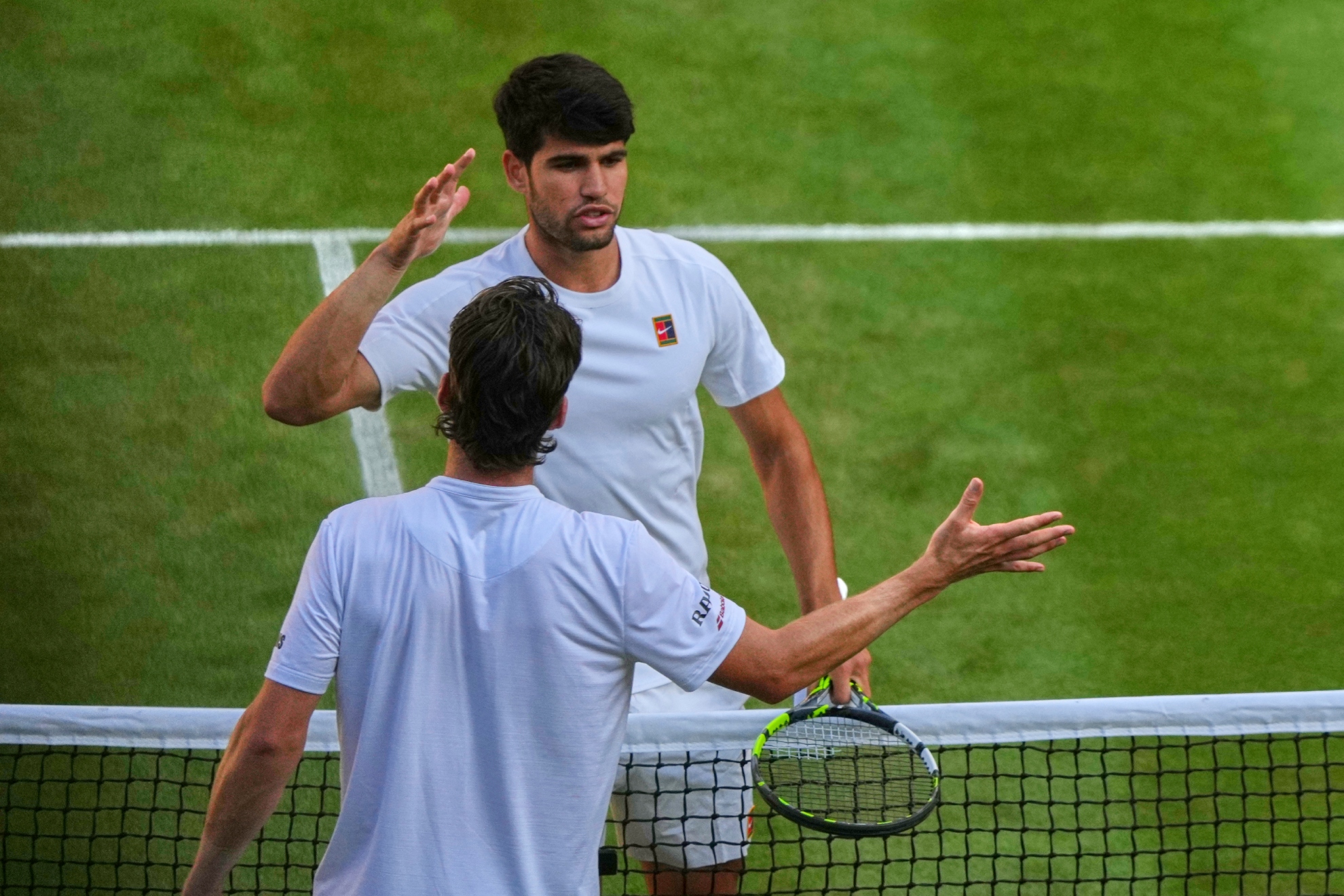 Alcaraz y Norrie se saludan en los cuartos de final de Wimbledon 2025.