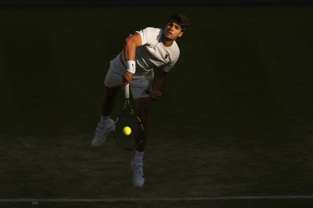 Spain's Carlos Alcaraz serves to Britain's Cameron Norrie during a quarterfinal men's singles match at the Wimbledon Tennis Championships in London, Tuesday, July 8, 2025. (AP Photo/Joanna Chan)