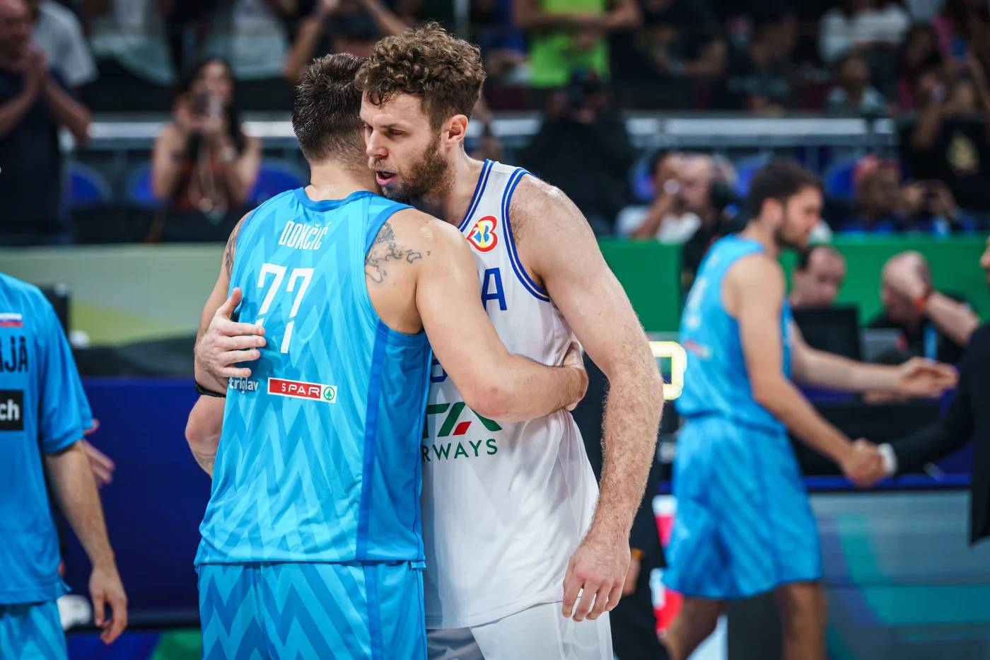 Nicolo Melli and Luka Donci greet themselves during a match between Slovenia and Italy.